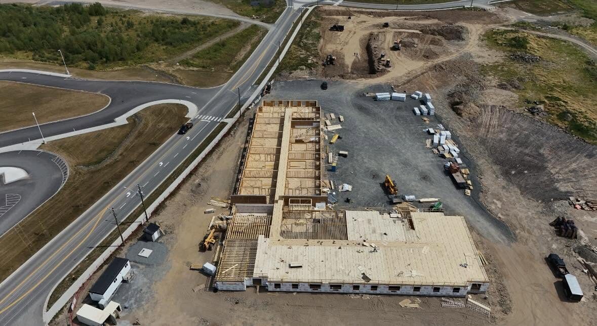 Site view of the building early in framing with material staged alongside