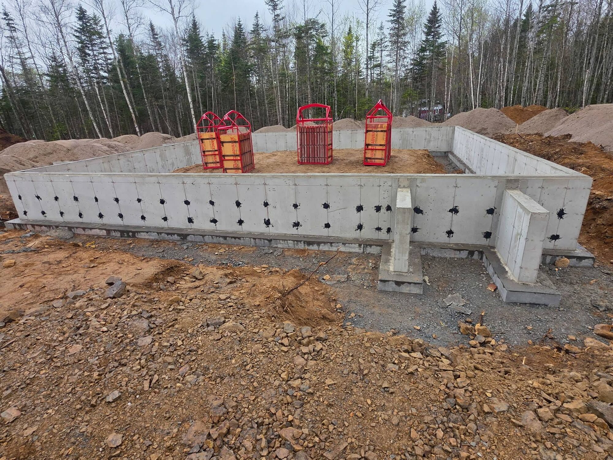 Formed and stripped foundation walls for a spec house on a wooded lot at Durham Bridge