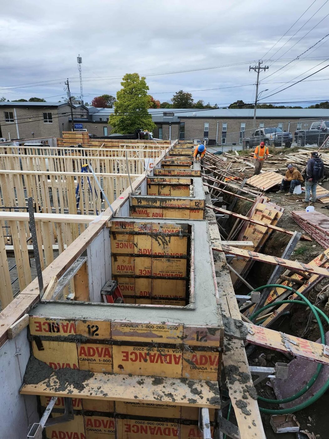 Crew working the wall forms from the top of the braced formwork