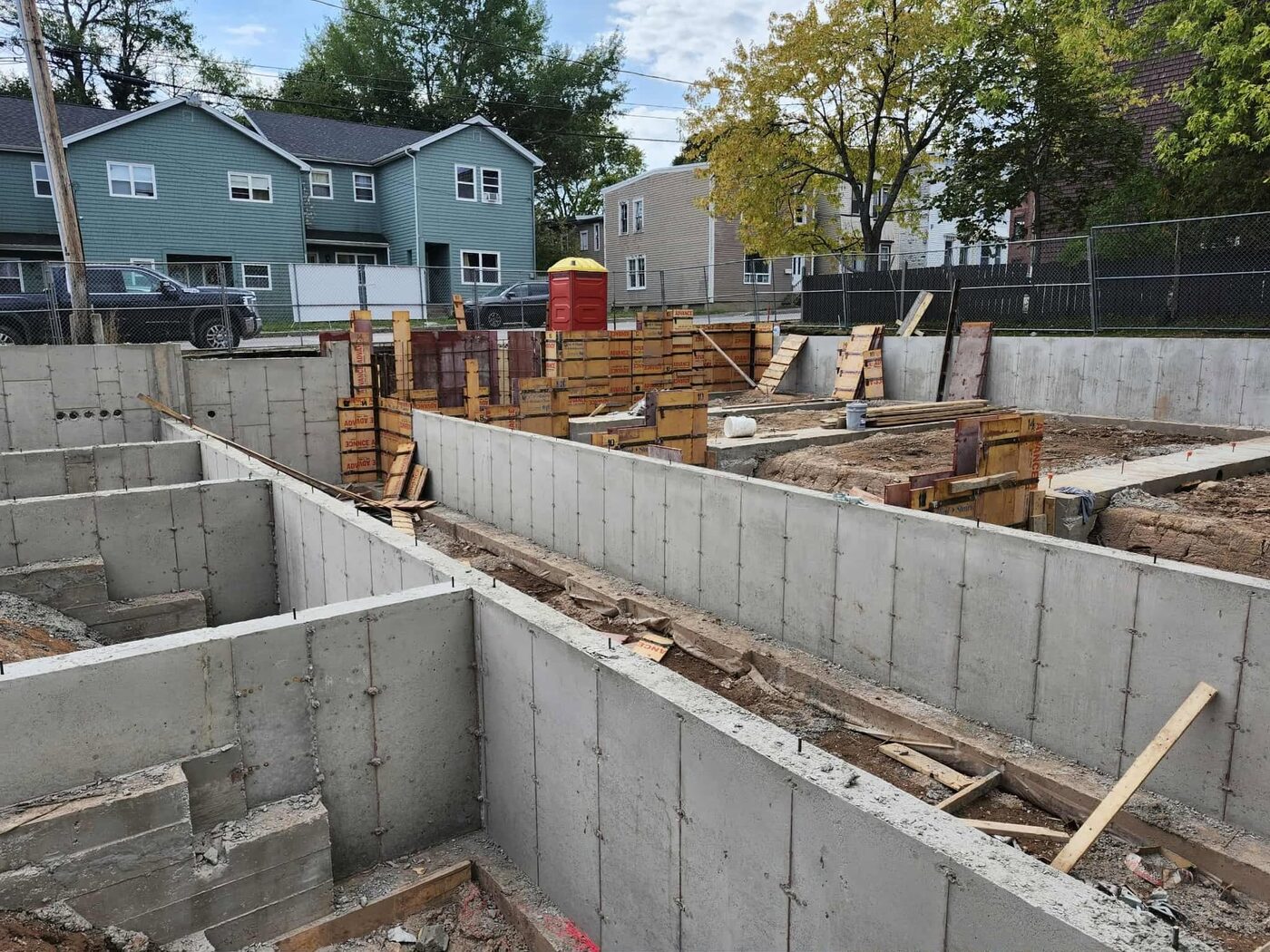 Foundation walls stripped, showing snap-tie holes and the interior bearing wall