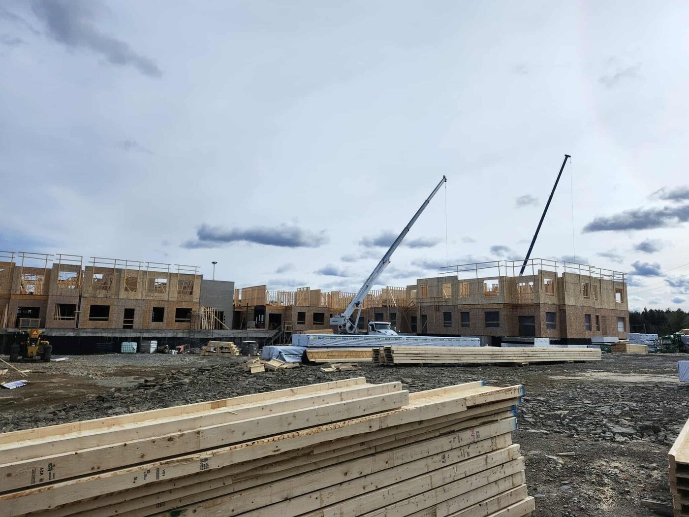 Cranes working over the long concrete wall run